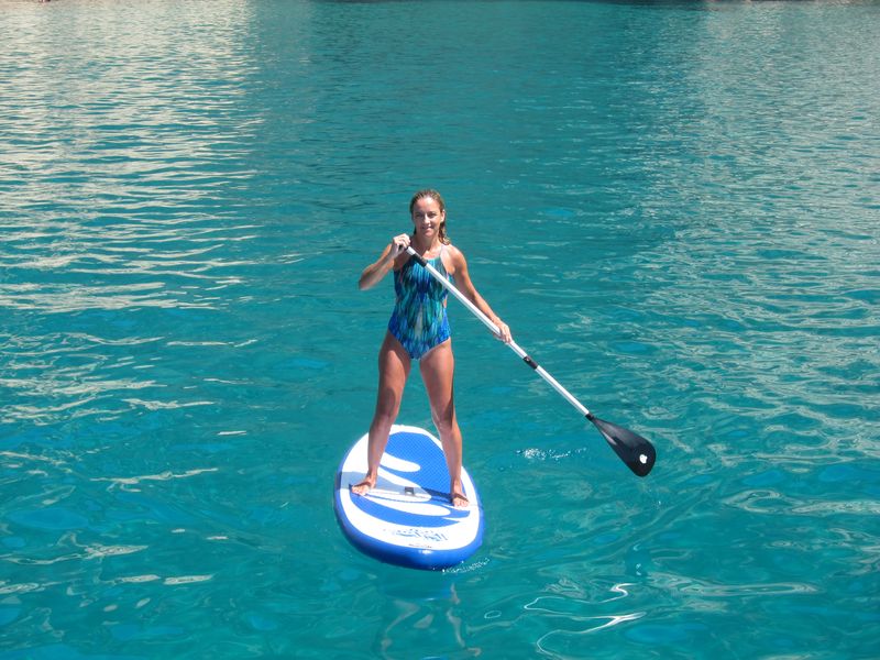 Grupo sevillanos alquiler veleros con patrón en Ibiza. María demostrando su destreza con el paddle surf