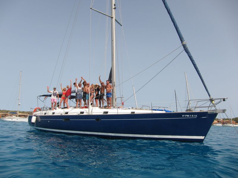 Group of friends posing on the deck of their sailing boat Ibiza
