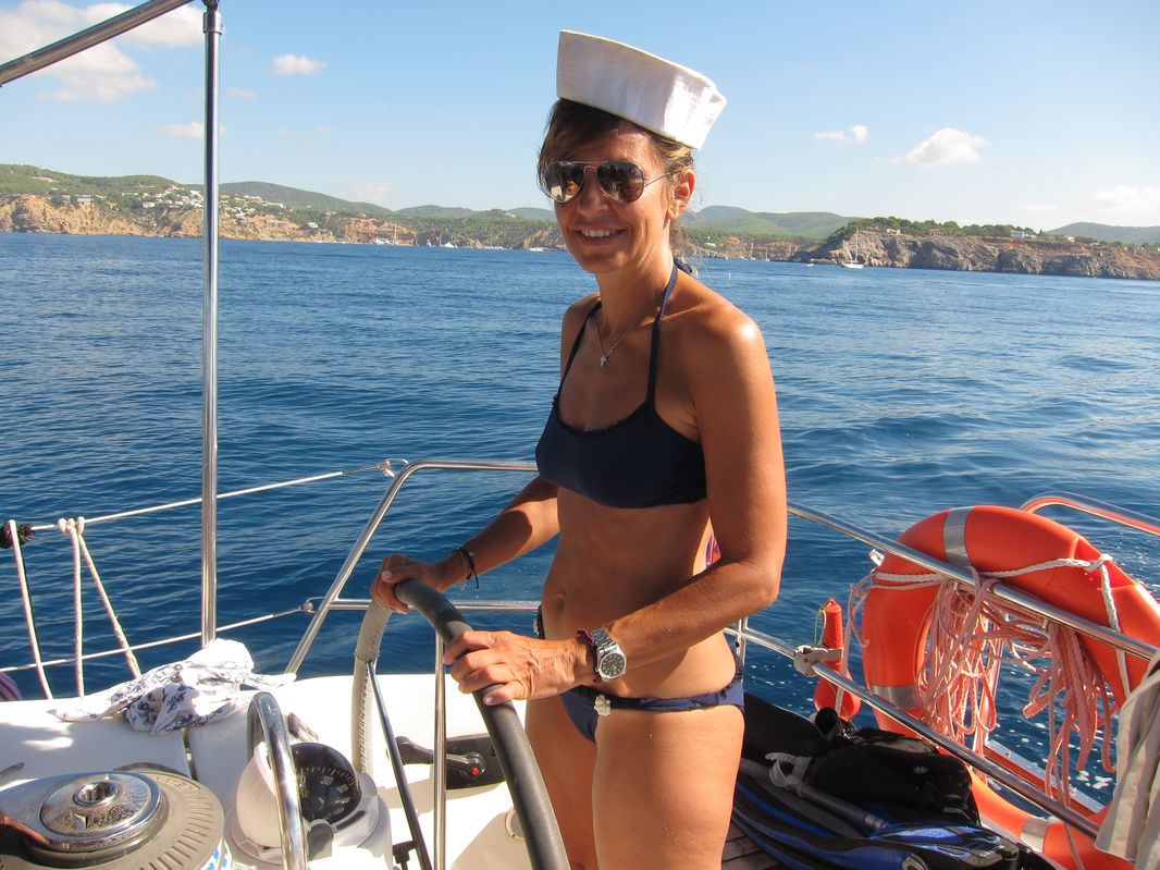 Alessandra con un gorro marinero llevando el timón